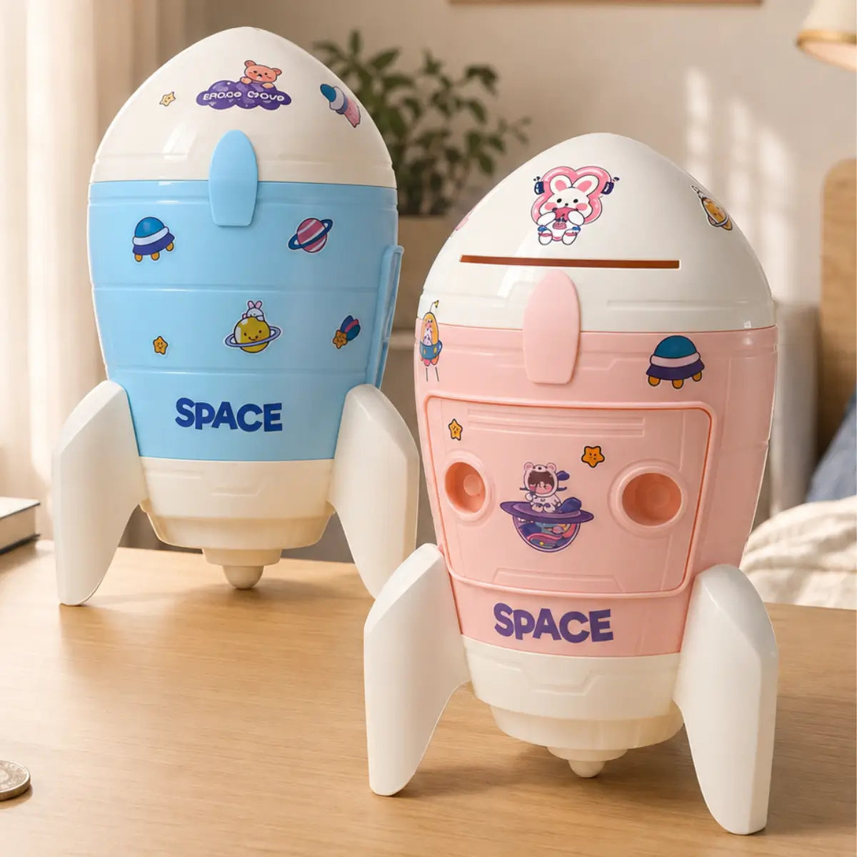 Alcancía infantil con diseño de cohete en colores azul y rosado para niños