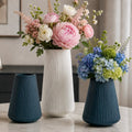 Floreros decorativos estriados en colores azul y blanco con arreglos de flores