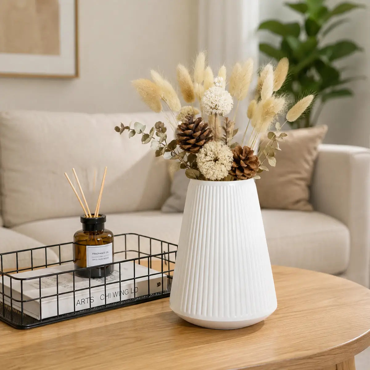 Florero decorativo blanco con textura estriada y arreglo de flores secas