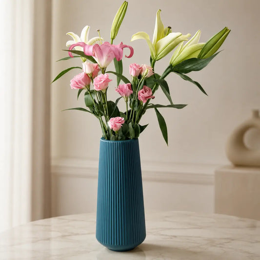 Florero decorativo azul de diseño estriado con flores rosadas para sala o comedor
