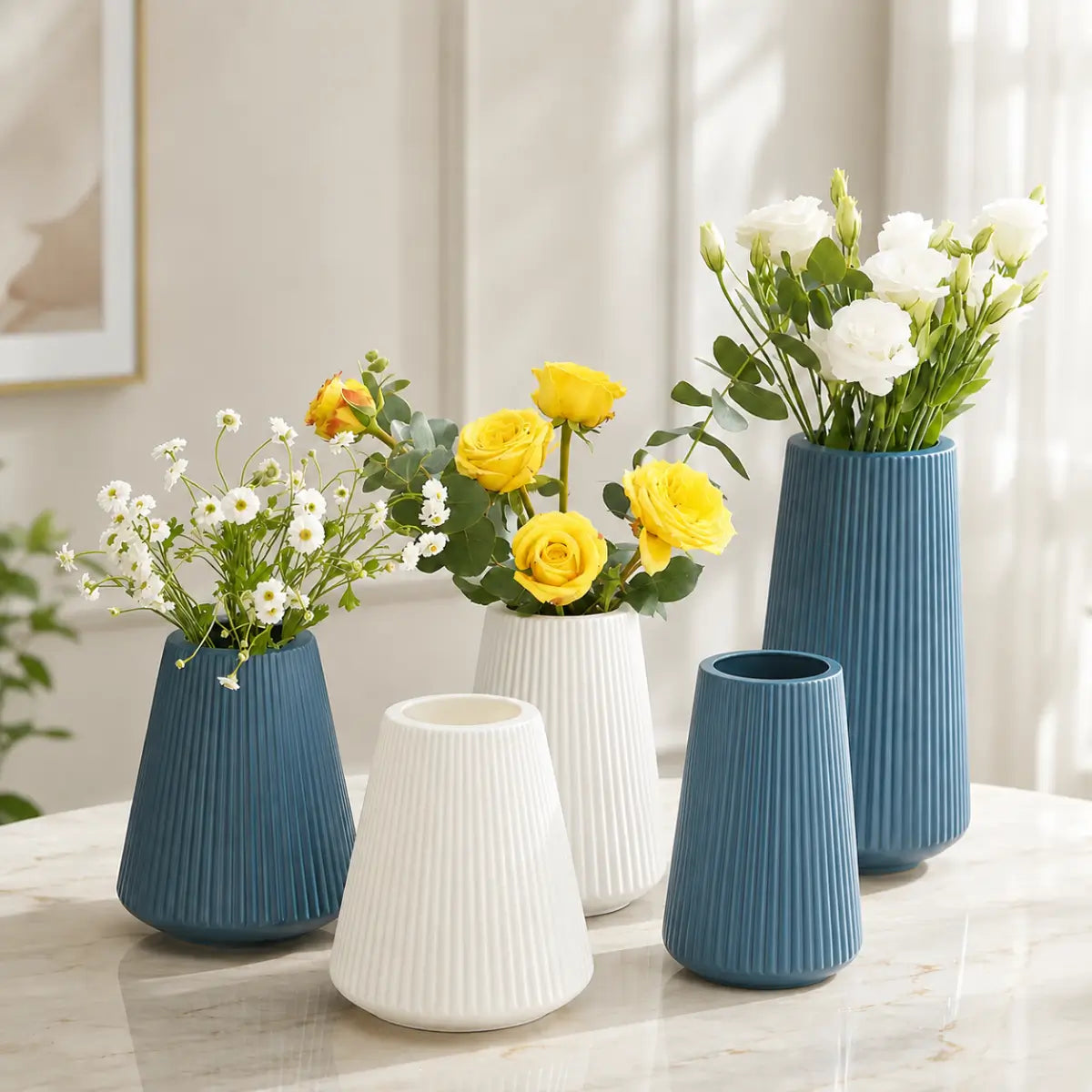 Floreros decorativos estriados en azul y blanco con diferentes tamaños y arreglos florales