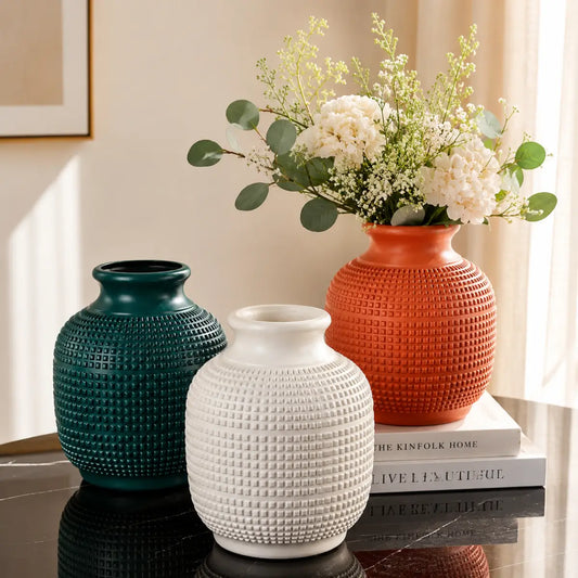 Floreros decorativos con textura en relieve en colores verde oscuro, blanco y terracota
