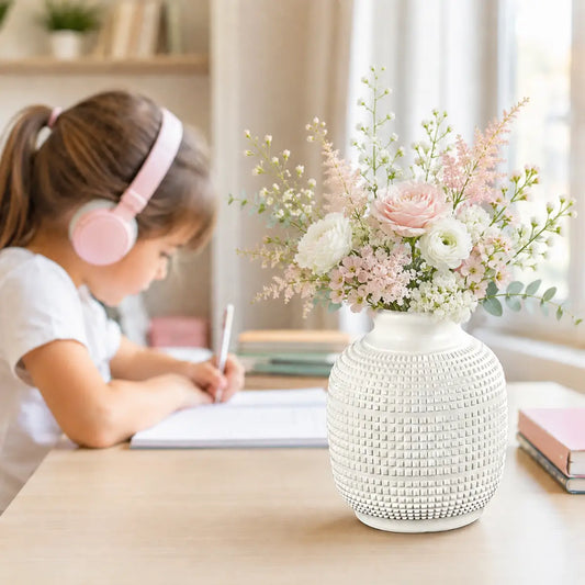 Florero decorativo blanco texturizado con arreglo de flores en ambiente interior