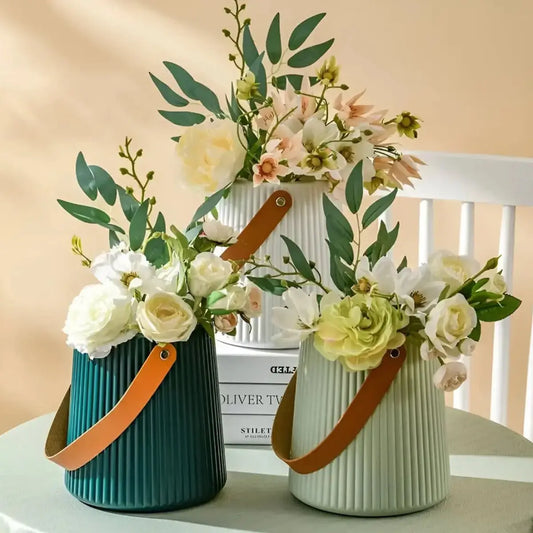 Florero decorativo estriado con asa marrón en colores verde oscuro y verde claro con arreglos florales