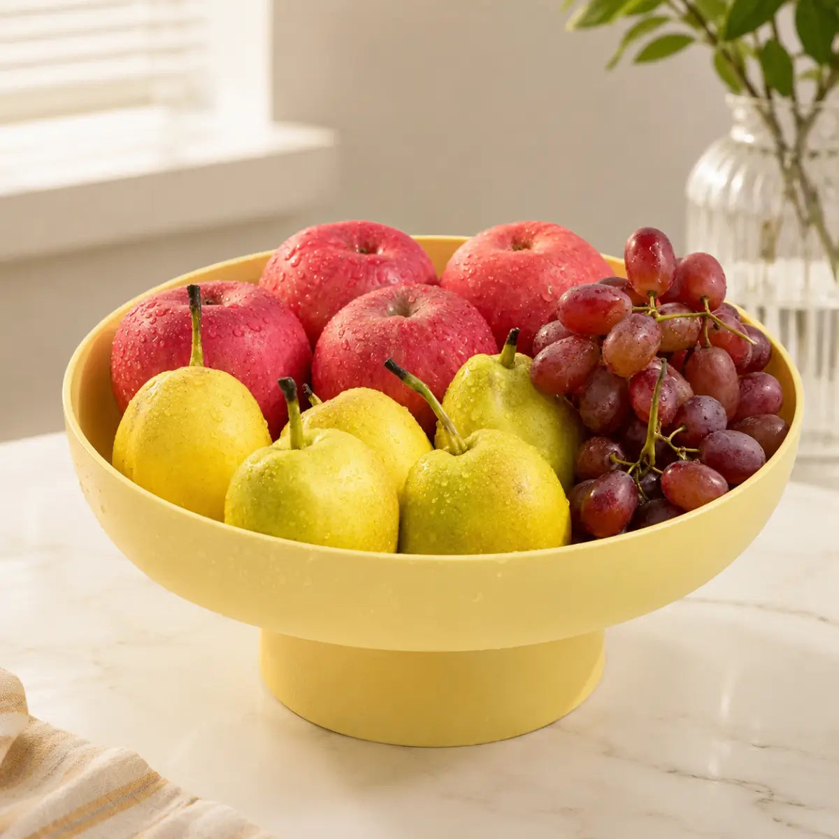 Frutero con base desmontable color amarillo para organizar frutas sobre la mesa